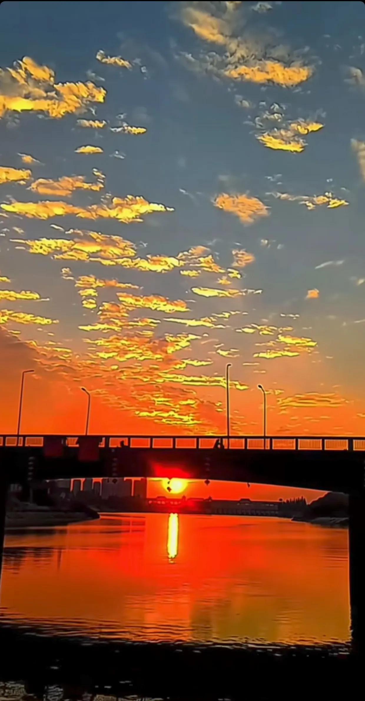 夕阳洒金，天空如画，桥洞间的余晖映照出浪漫与温馨。晚归的身影在夕阳下显得格外喜悦