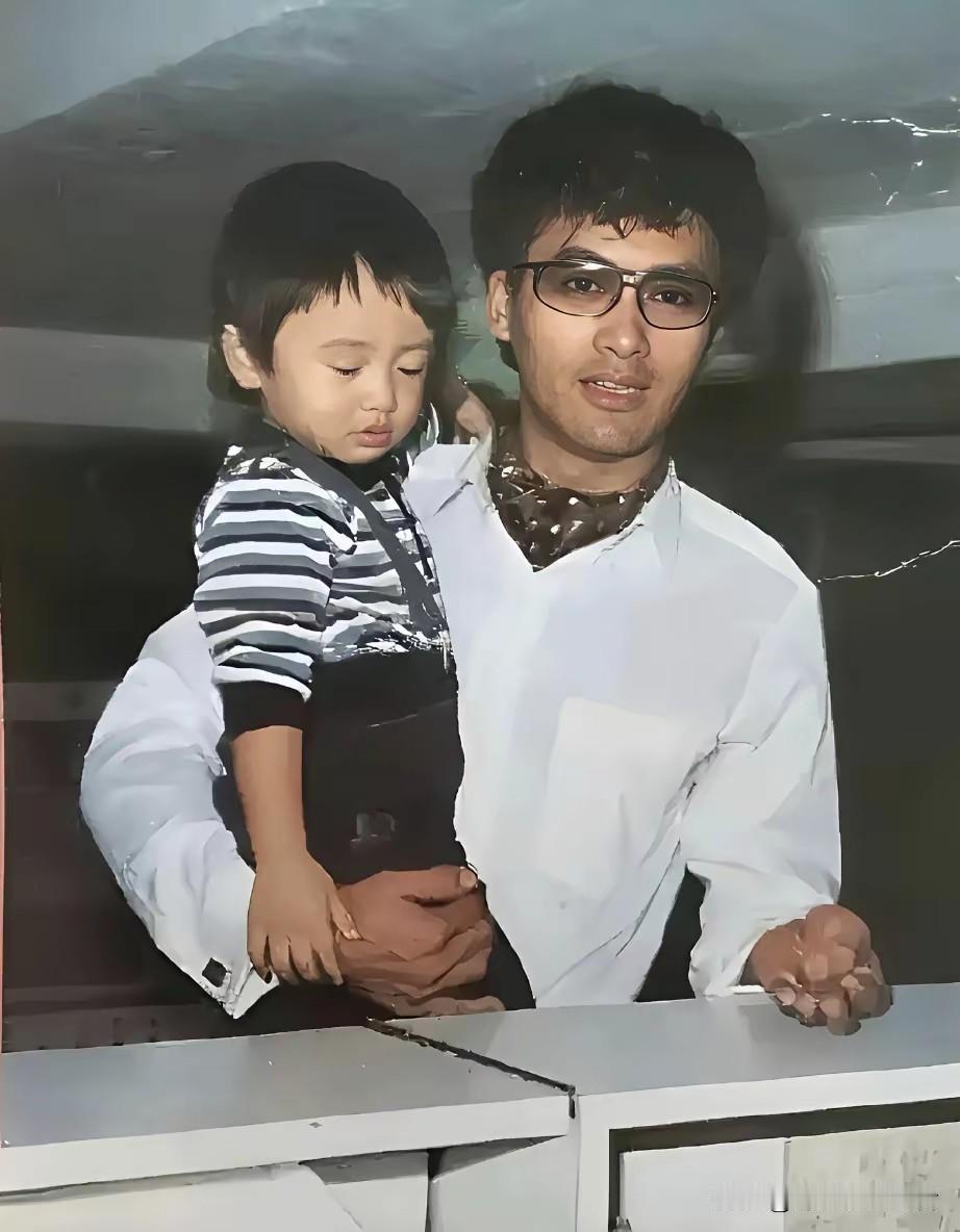 周润发抱着谢霆锋，那时候周润发也太帅气了，那个时候真的除了明星哪有穿的这么时髦衣