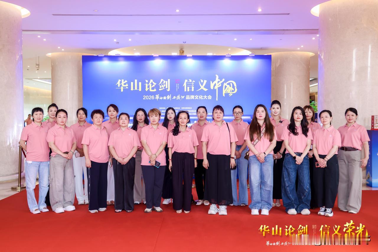 一群穿粉色衣服的人在红地毯上合影