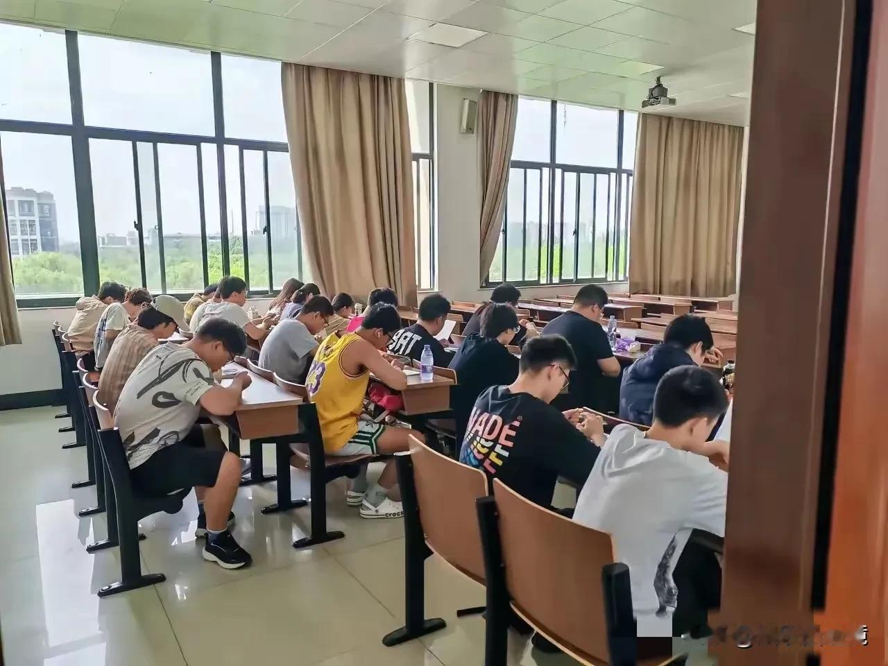 这张图片，生动的反映了很多高校大学生上课时的真实现状。
从照片上看，前几排都是没