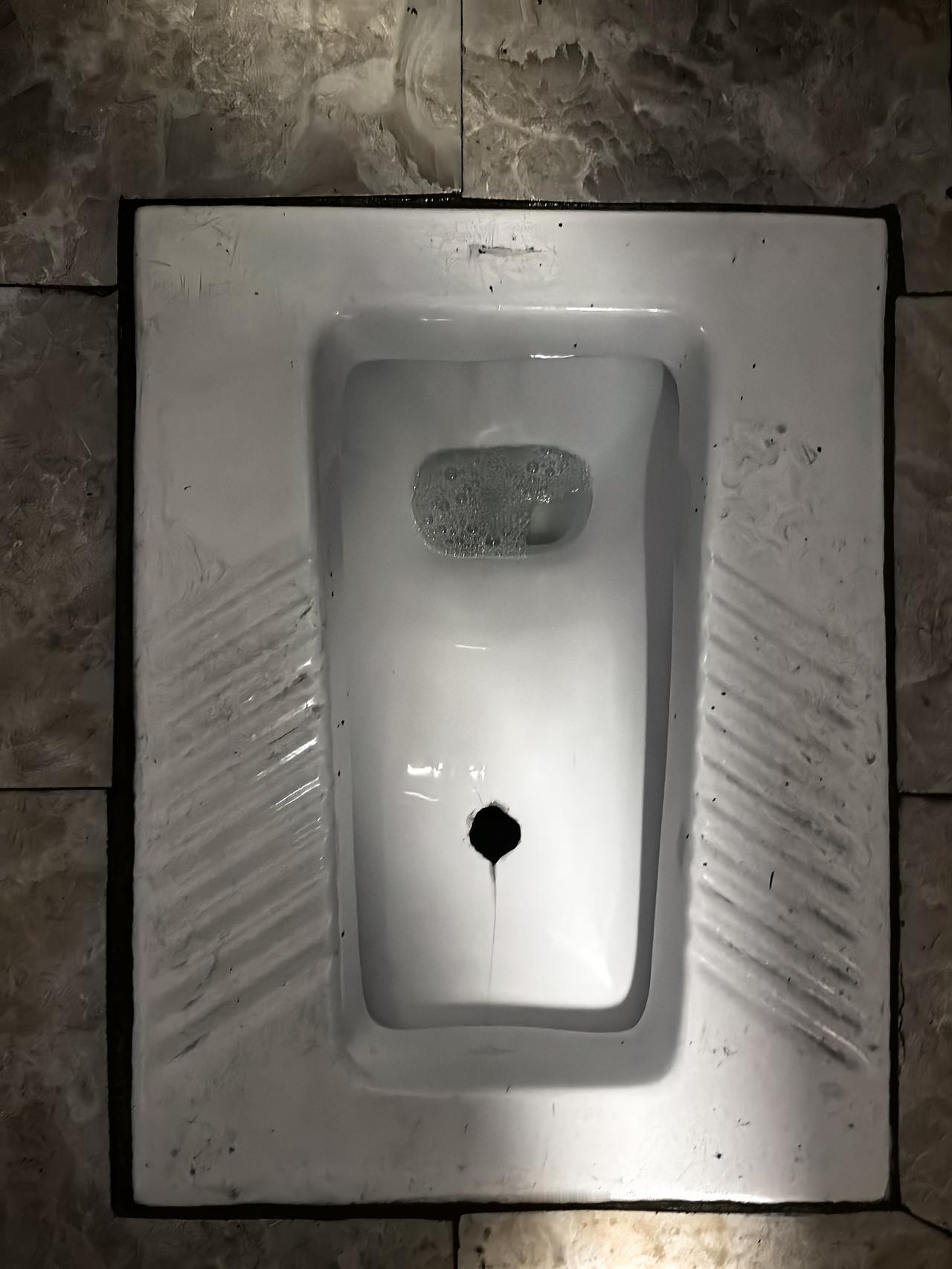 请教一下哈，如图，厕所  卫生间的陶瓷蹲便器，本来好好的，为什么要故意打一个孔呢