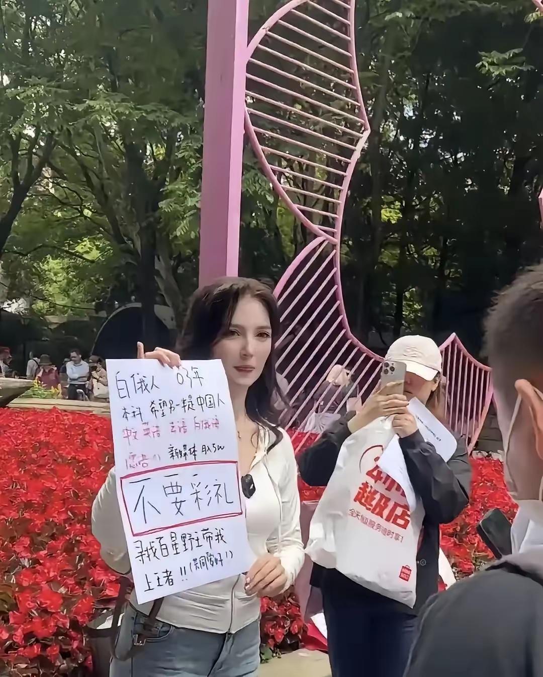 上海人民公园相亲角最近出了个稀奇事，一个金发碧眼的白俄罗斯姑娘坐在那，不要车也不