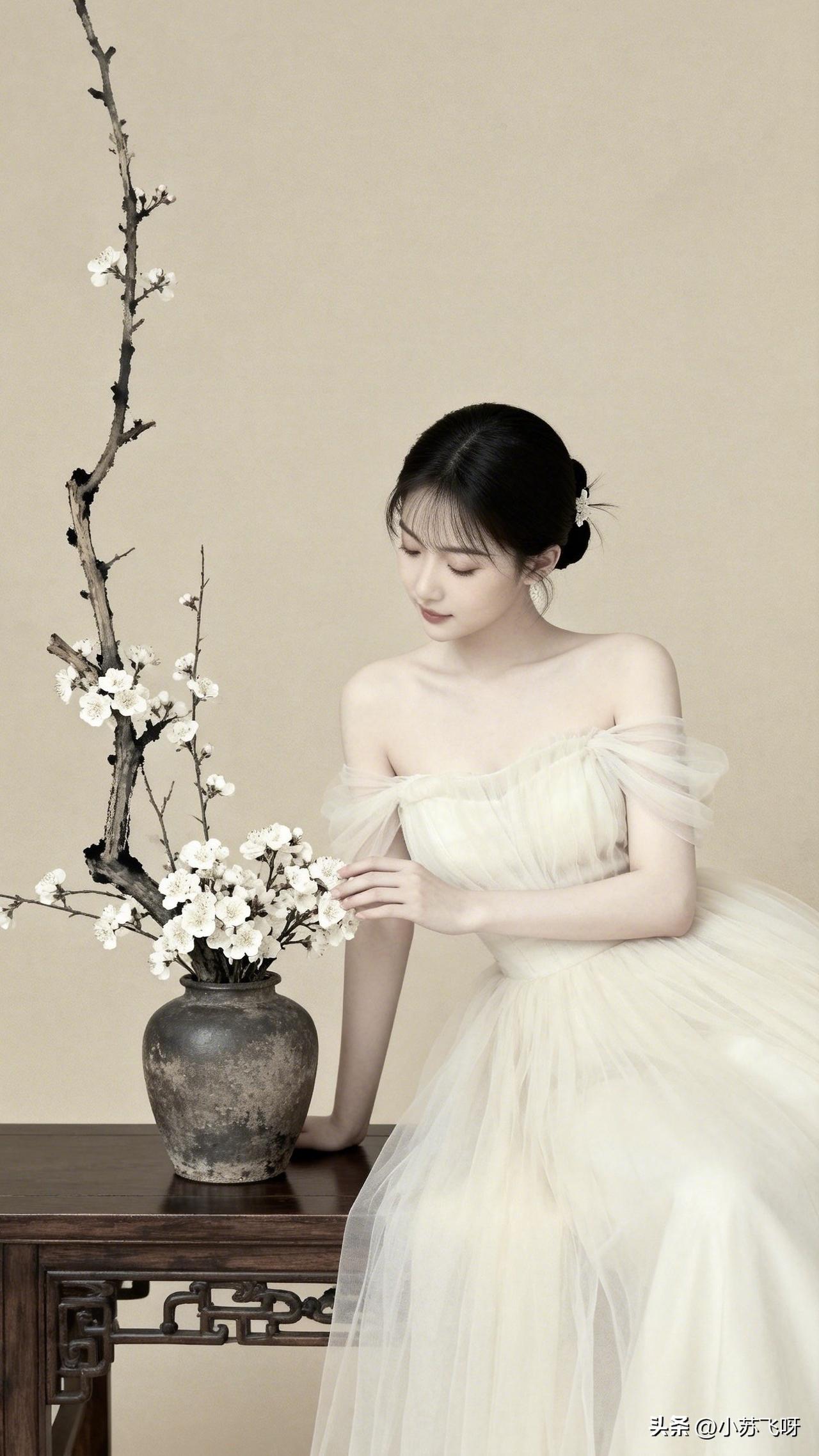 ：‘’低头抚花意韵长，
纱影通透映容光。摆拍痕迹悄然逝，画面如诗梦亦香…………‘