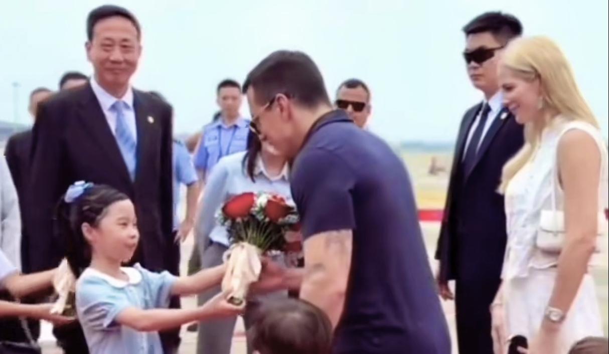 这位总统年轻帅气，携夫人、儿子来华访问。非正式场合，穿贴身体恤衫；红毯上牵手儿子