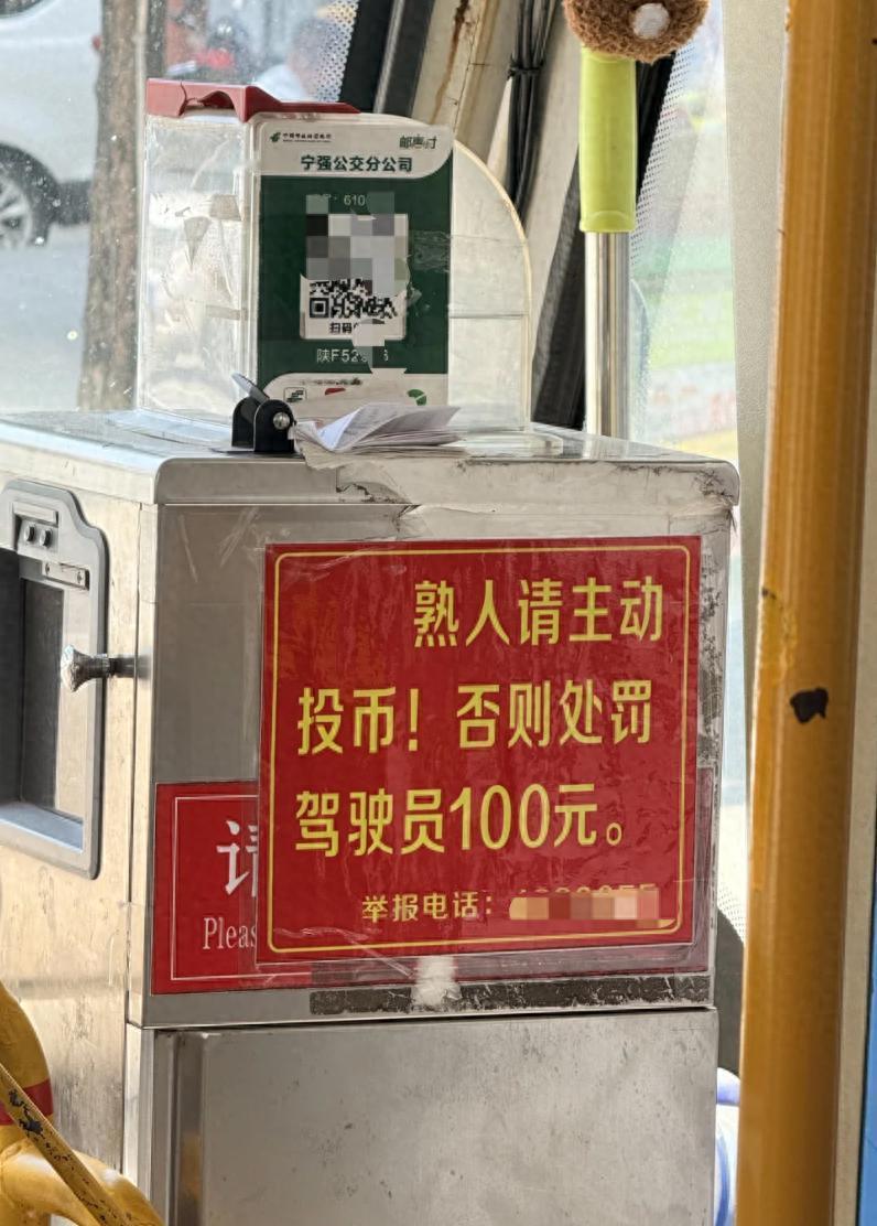 陕西汉中宁强县的一辆公交车上，投币箱贴着一块红底黄字的提示牌，上面写着 "熟人请