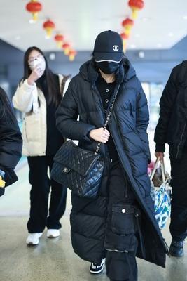关晓彤机场穿搭：黑色长款羽绒服配Chanel大包包，温暖低调中散发出十足的时尚魅