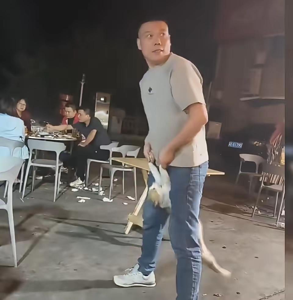 这男子晚上去吃大排档，不知道是喝了点酒有点醉了还是想故意恶作剧，趁烧烤店老板不在