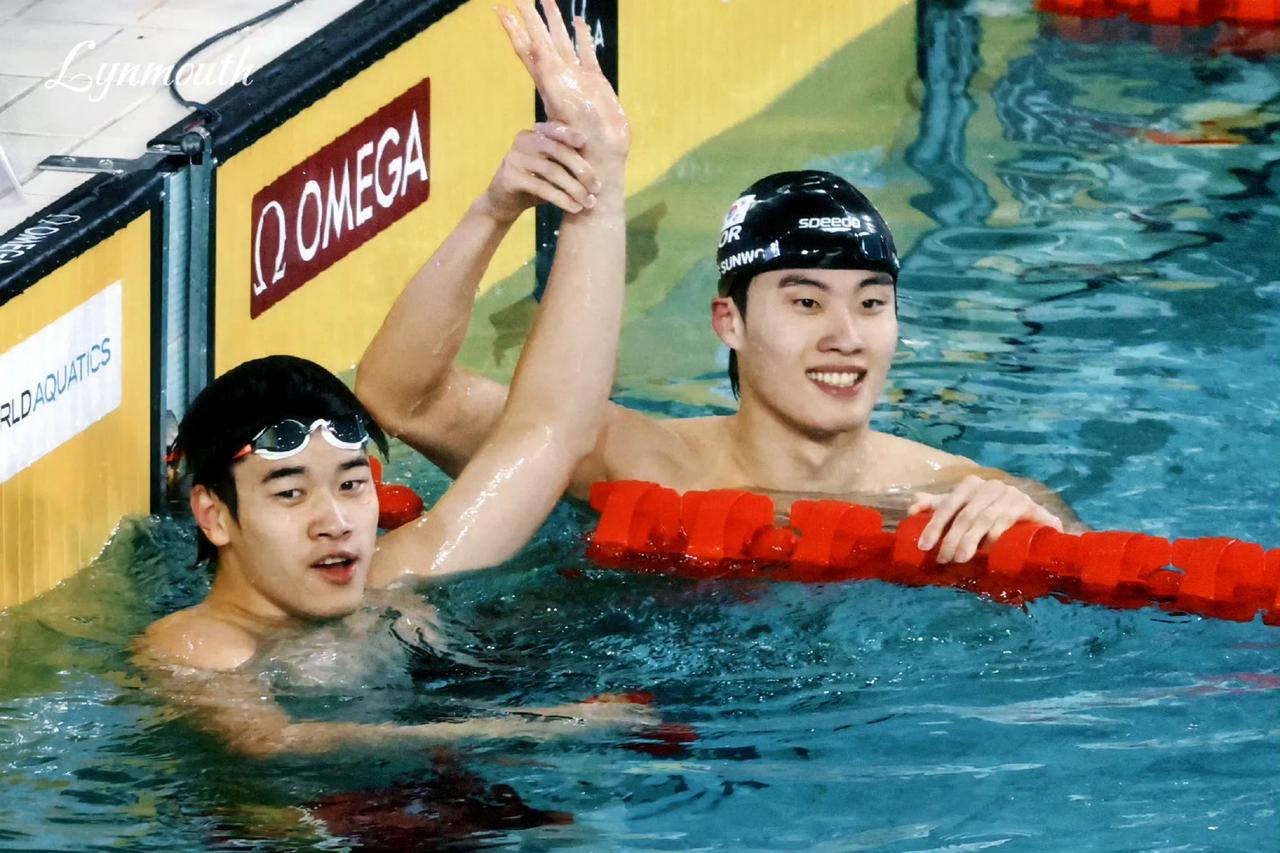 泳池边的潘展乐被韩国对手高高的举起手。一脸崇拜的样子，仿佛在说，他的实力真的很强