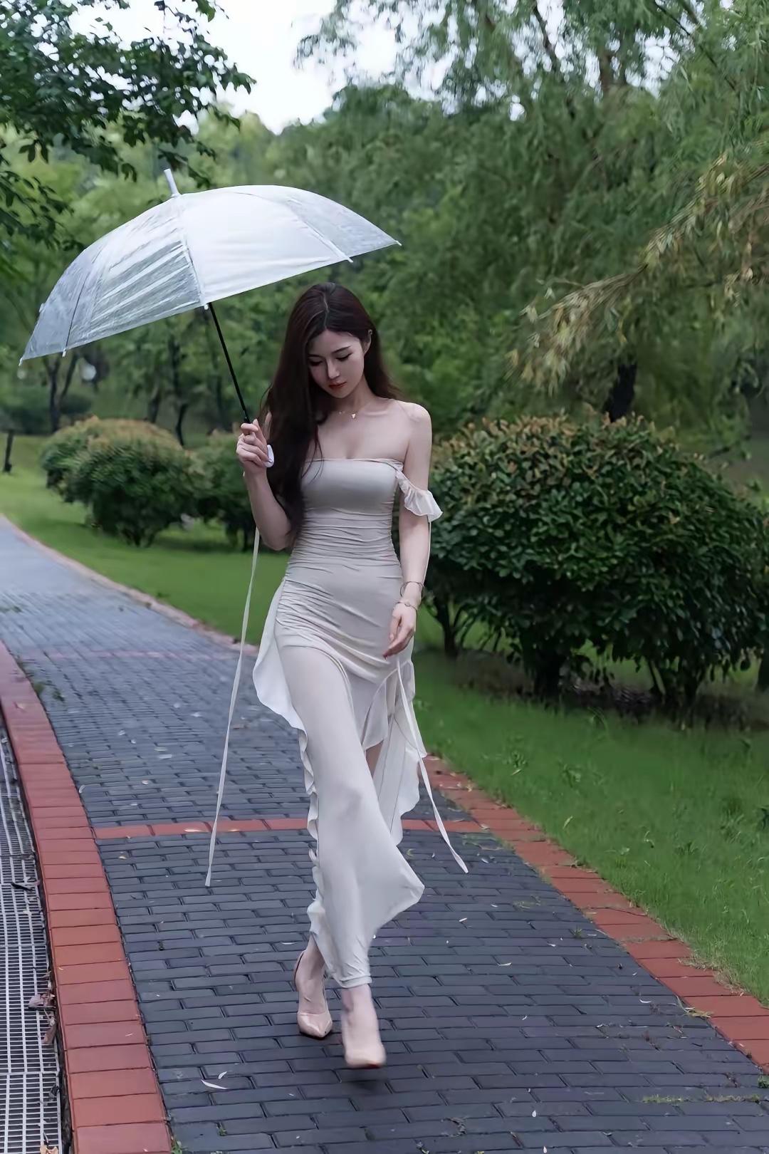 雨中漫步，撑伞漫步在绿意盎然的公园小径上，优雅动人。