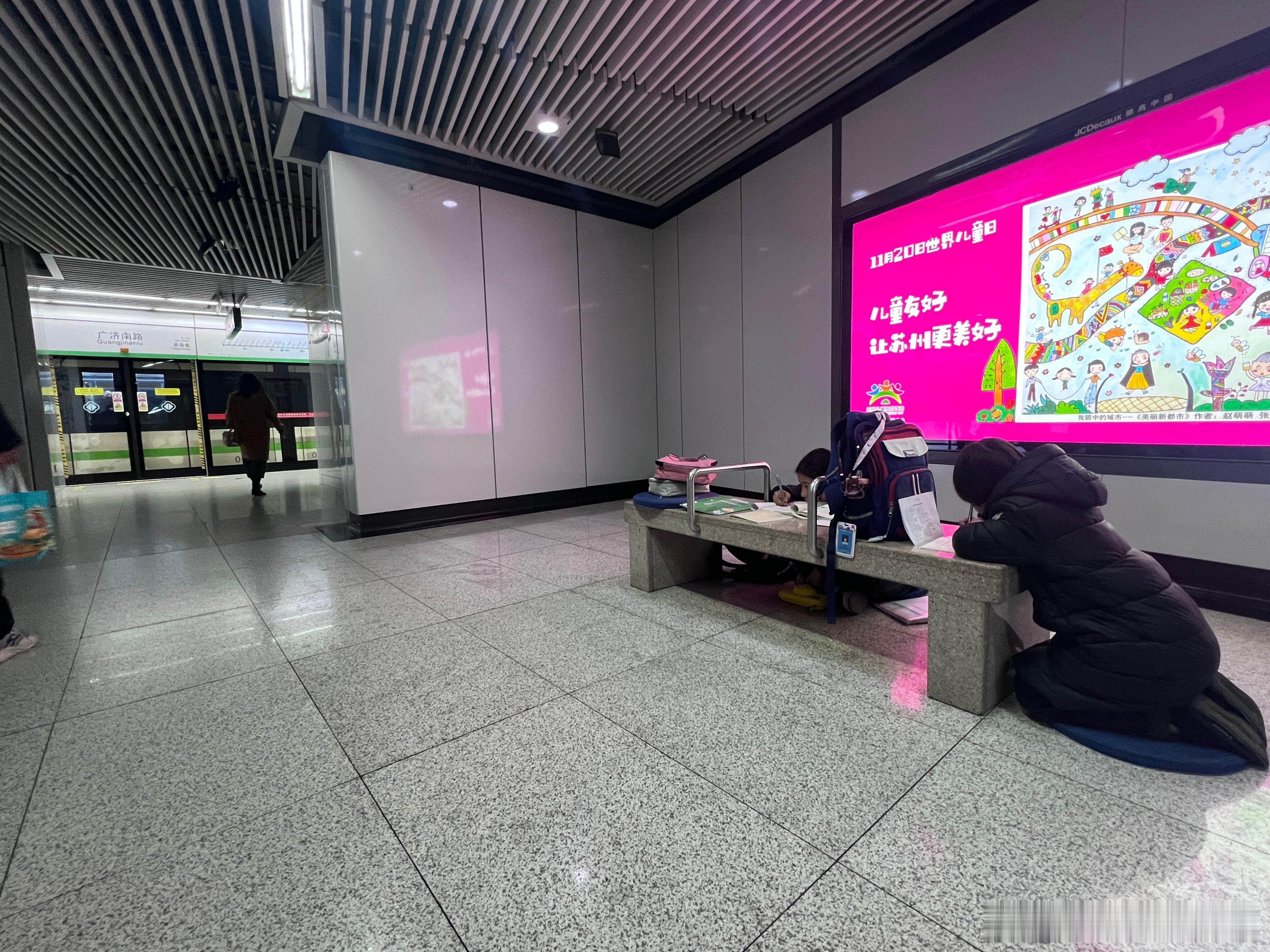 地铁站 世界儿童日  广告前两个孩子在趴着写作业，多少有点…… 