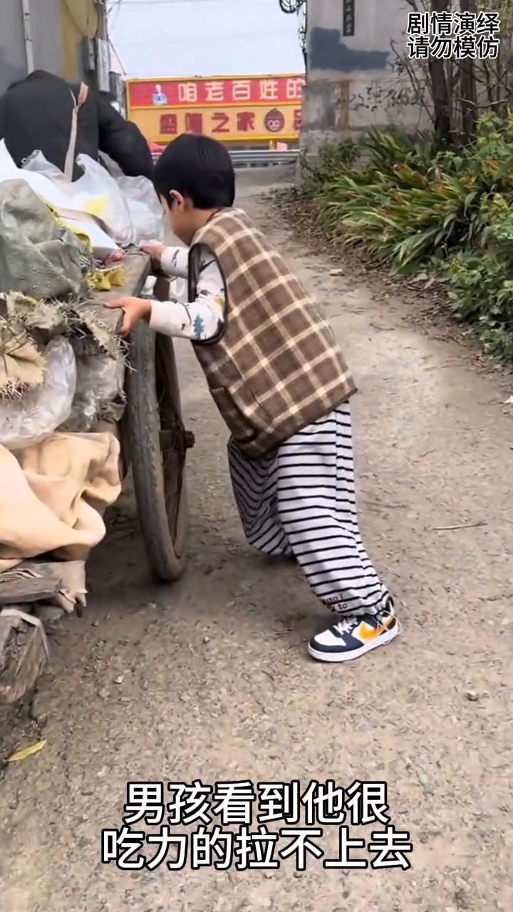大叔拉平车上坡遇到困难，下一秒男孩看到毫不犹豫帮助他。
一位大叔拉着平车在上坡，