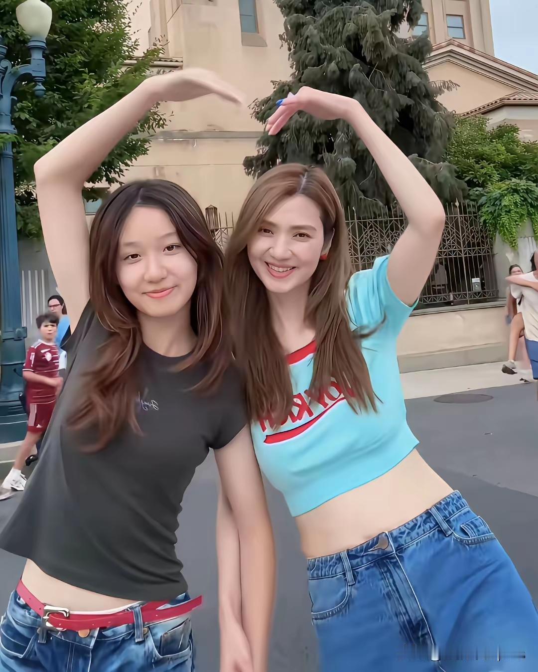 年龄在顶级美貌面前就不算什么了。洪欣和女儿合影，母女二人合比了一个红心。
洪欣的