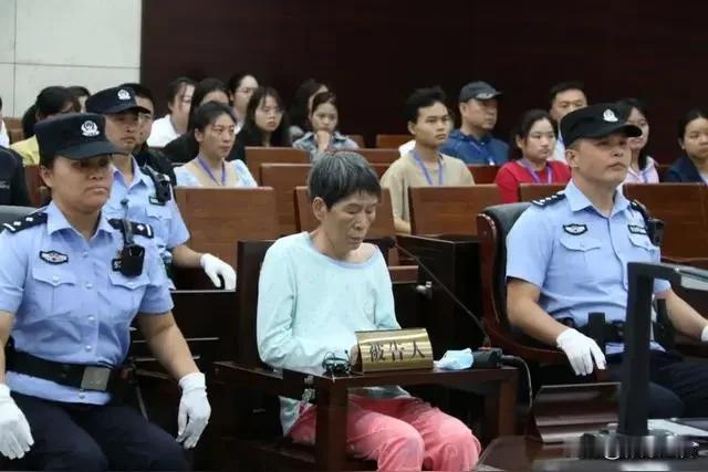 图片中这个女人就是人贩子余华英，她低着头，目光呆泄，接受法律的审判，本该安享晚年