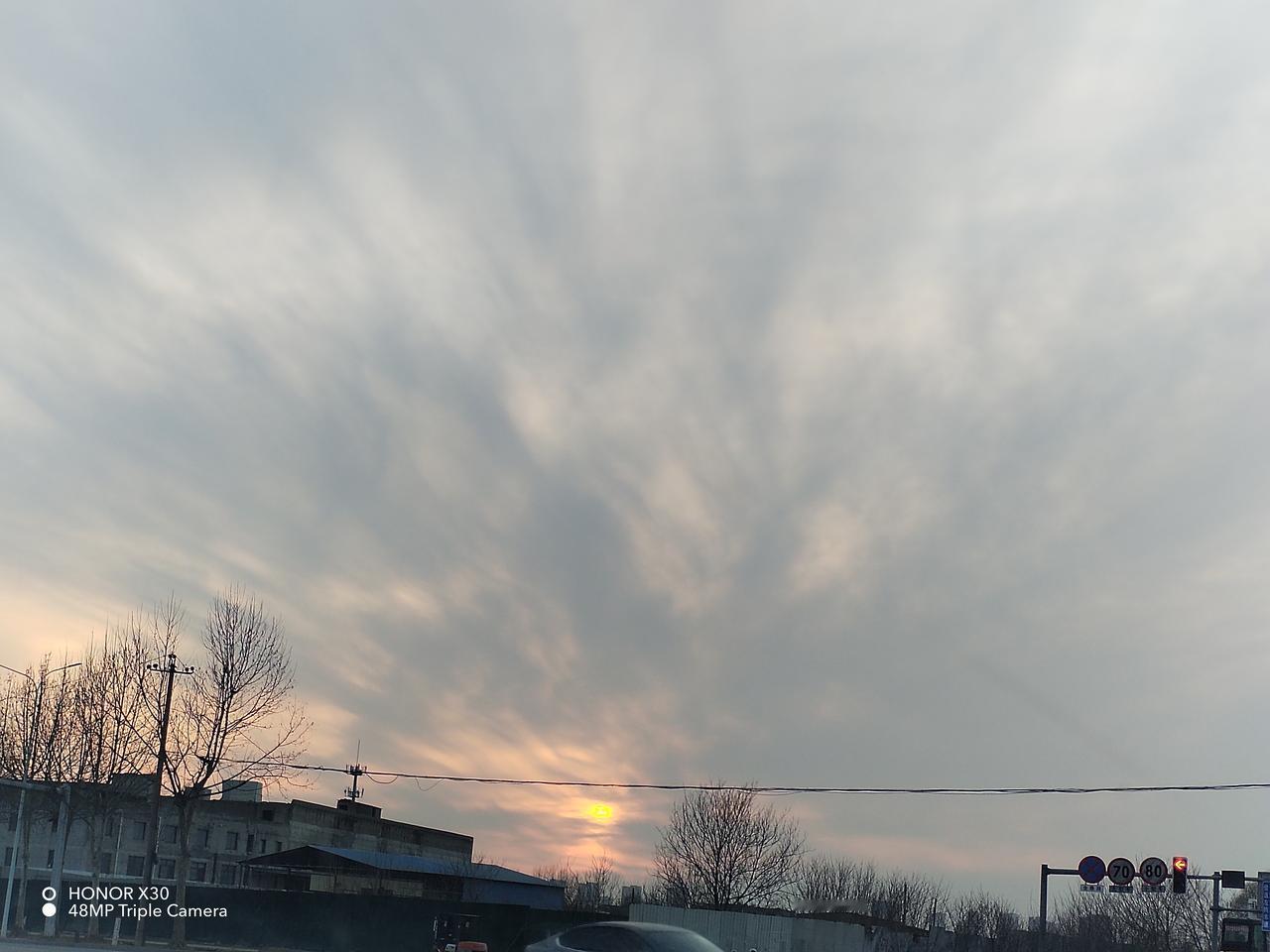 今天出门，随手就拍了一张夕阳西下的美景。那落日像个大火球，慢慢下沉，把天空染成了