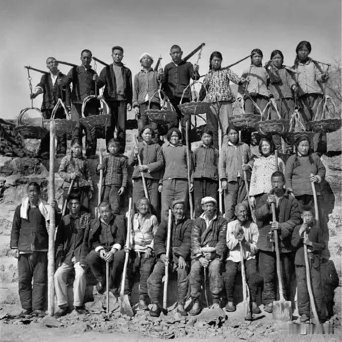 1974年，河南辉县，荒滩造田的民工们的合影,手里拿着原始的生产工具。

这张照