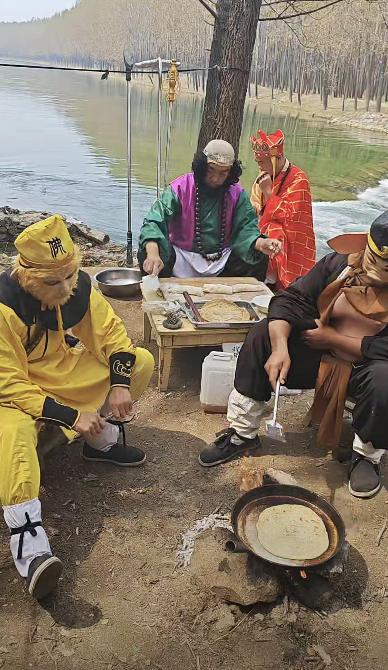 西天取经，这是取到了“人间烟火”。树下河畔的简易小桌，铁锅烙饼，炊烟袅袅，把“九