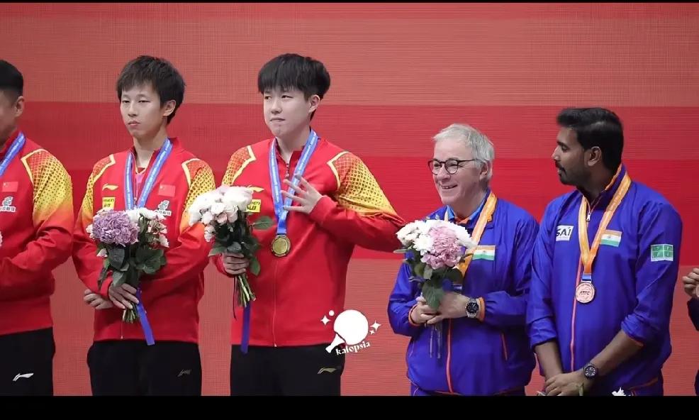 颁奖台上王楚钦的动作引起了印度队教练的注意，(ﾉಥ益ಥ)
询问大头要不要紧？
头