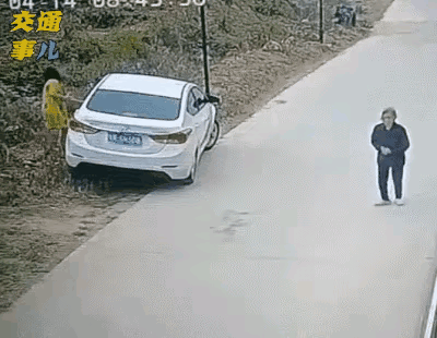 美女想把停在路边的小车调头，倒车时，错把油门当刹车踩了，小车箭一般退向对面的护拦