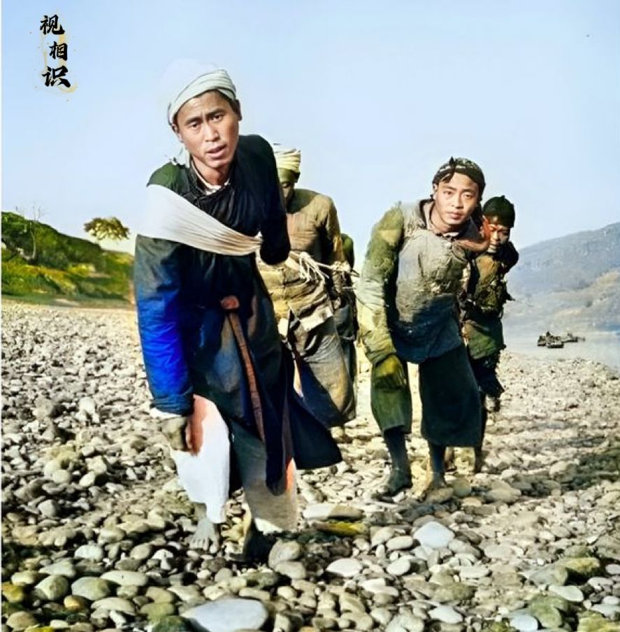 1946年，扬子江畔，一群纤夫正在拉船的照片，因为天气寒冷，他们穿上了衣服，在天...
