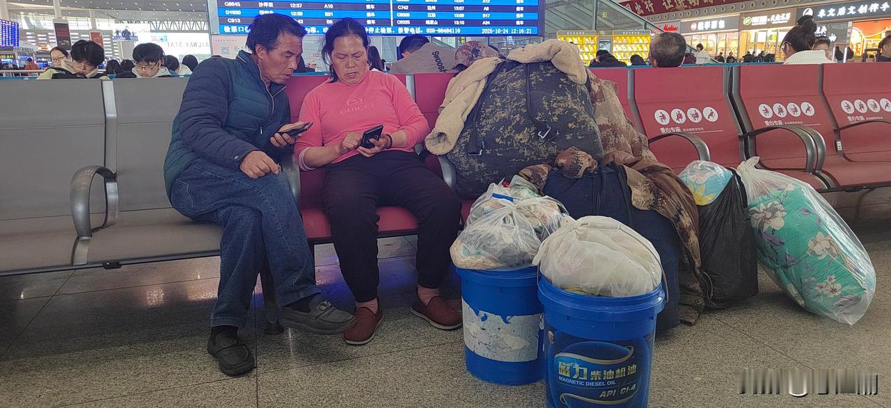 哀民生之多艰！成都东站一对夫妻背着一堆行李还带了两个装的沉甸甸的塑料桶，其中一个
