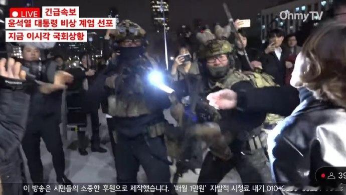 韩国士兵用枪指向要进入大楼的女议员。