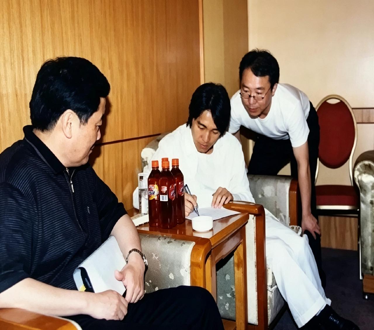2002年，星爷代言娃哈哈饮料签字现场。宗庆后坐对面盯着，桌上几瓶非常茶饮料。那