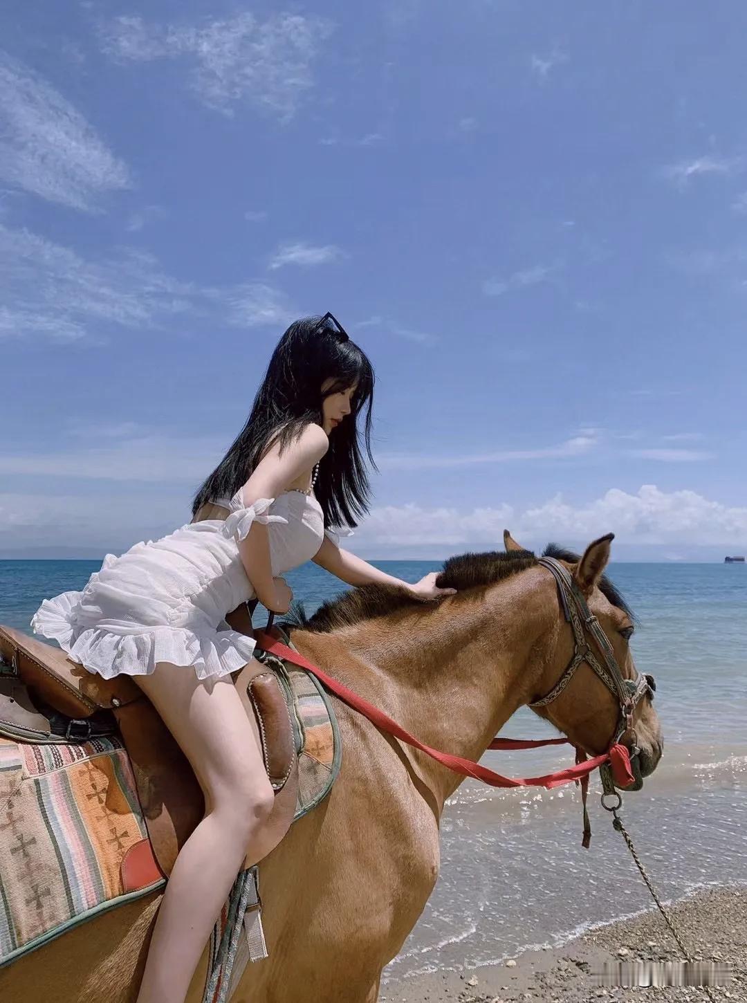 海边骑马，穿了条白色露肩裙。刚爬上马背其实有点慌，那马比我想的高太多。但等它慢慢