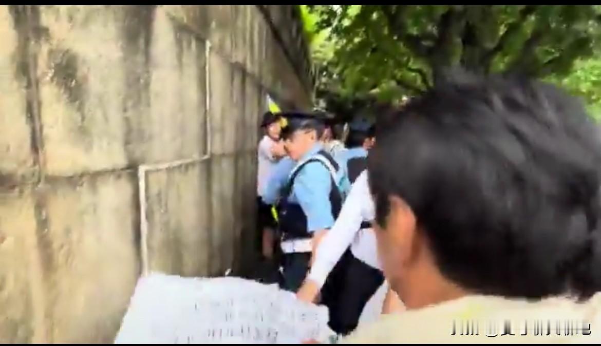 一名精日台独分子手持咒骂大陆的中文标语，昨天出现在靖国神社。一群日本民族主义者看