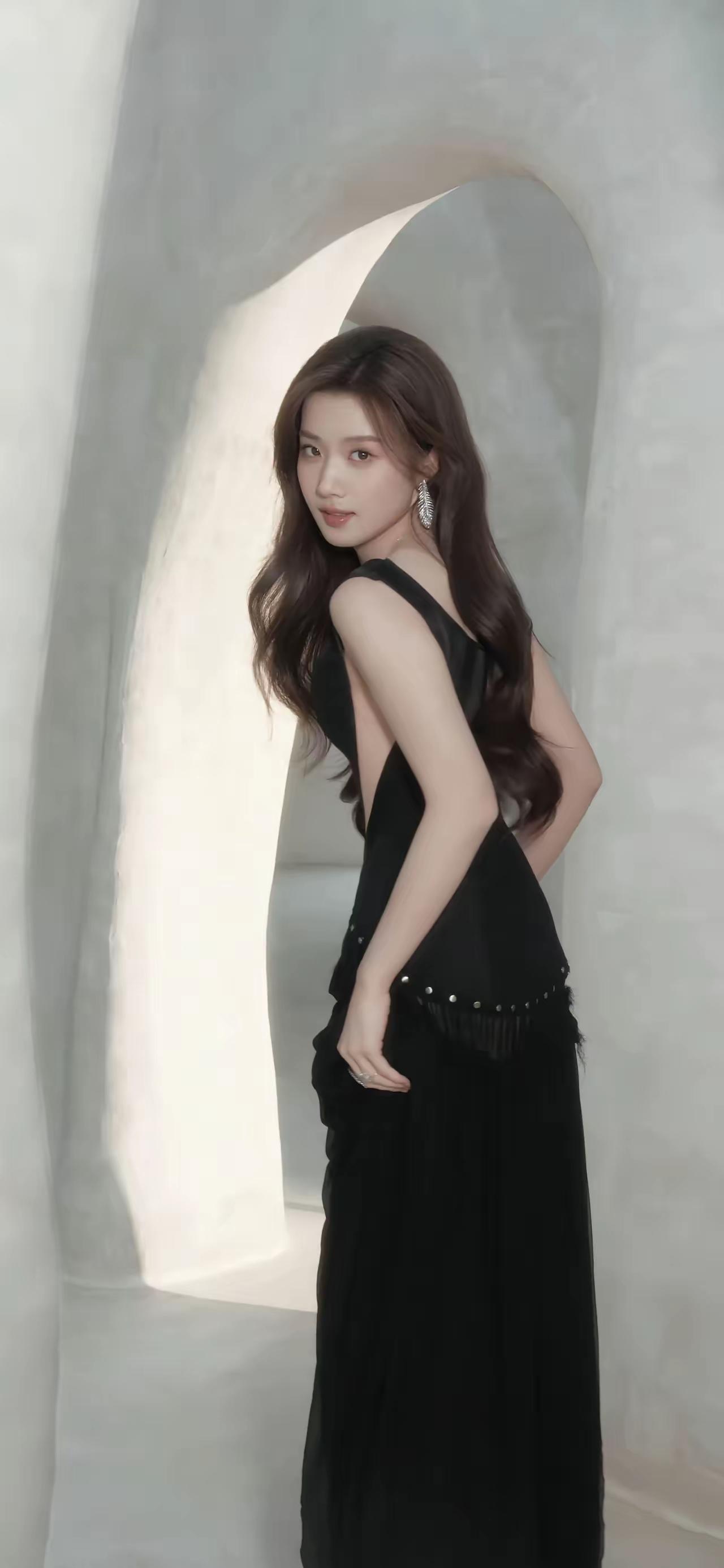 黑衣美人倚石壁，风姿绰约似仙子。