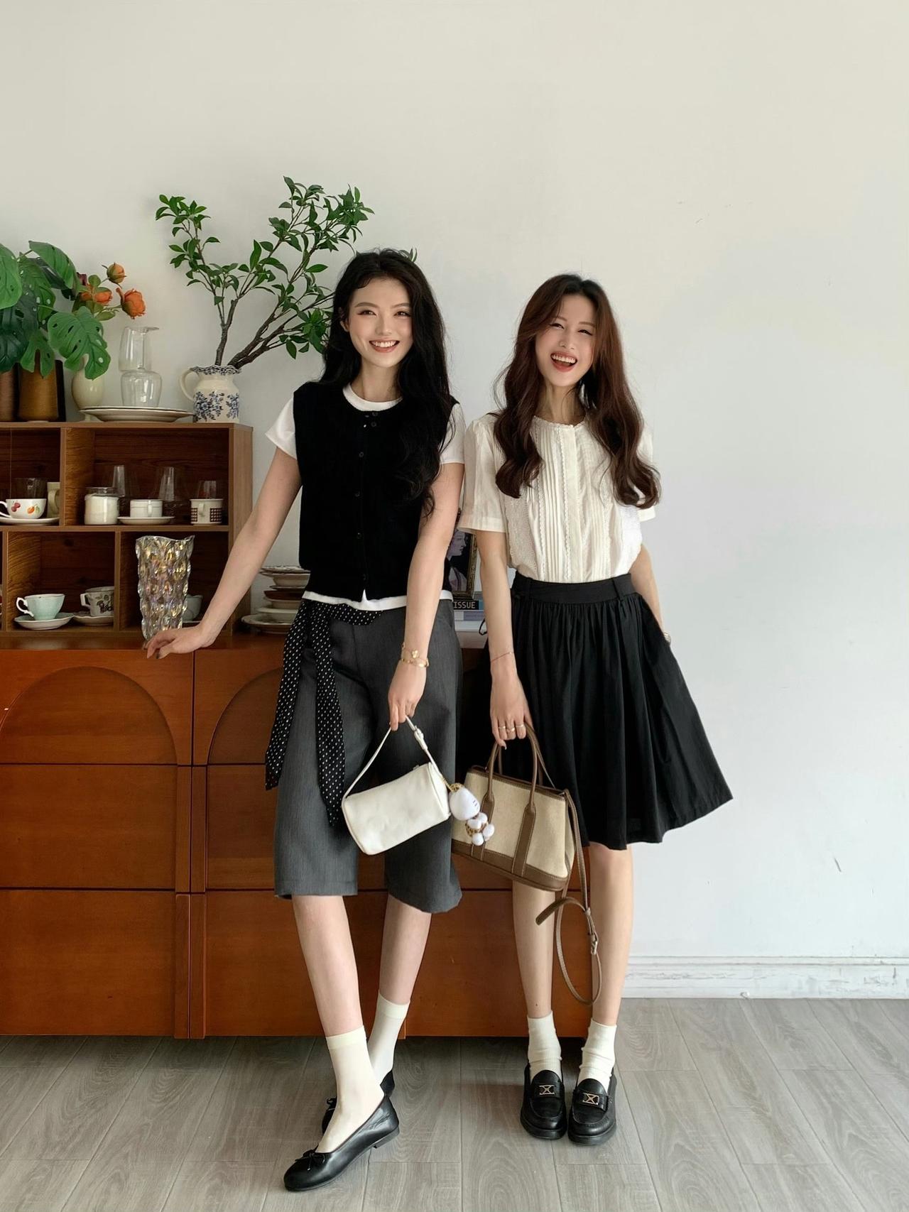 具有老钱风特点的通勤风格:左边的女生搭配了黑色马甲、白色内搭、灰色短裤和白色手提