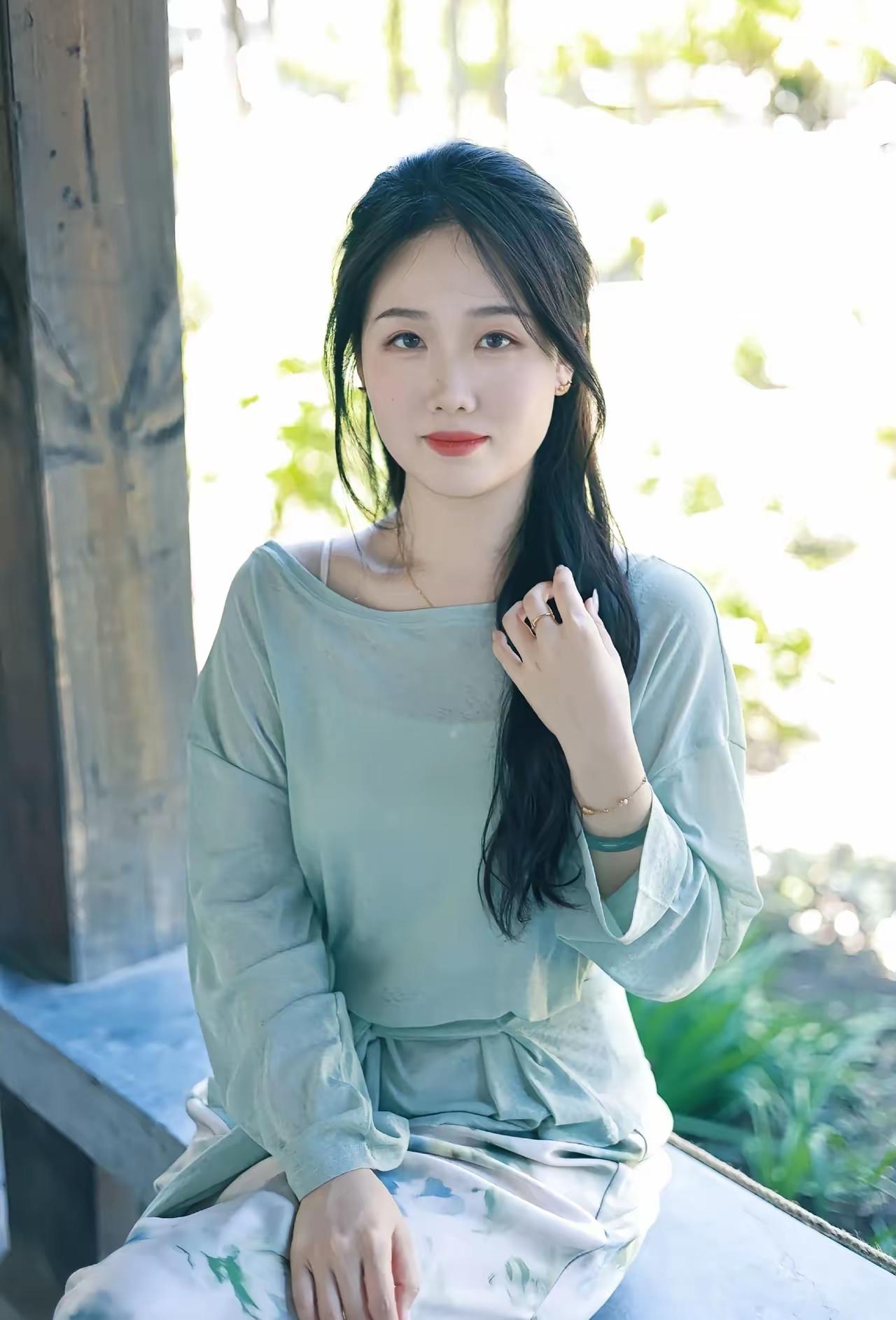 绿衣美人倚栏立，春光满面笑语生。