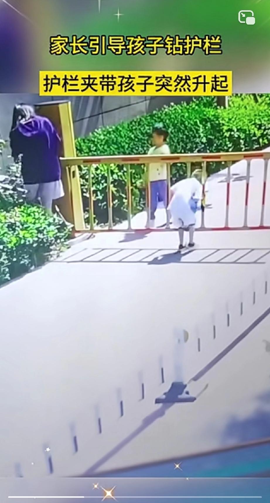 这个妈妈不靠谱，带孩子钻护栏，结果孩子被升起的栏杆吊挂在空中。妈妈想把孩子抱下来