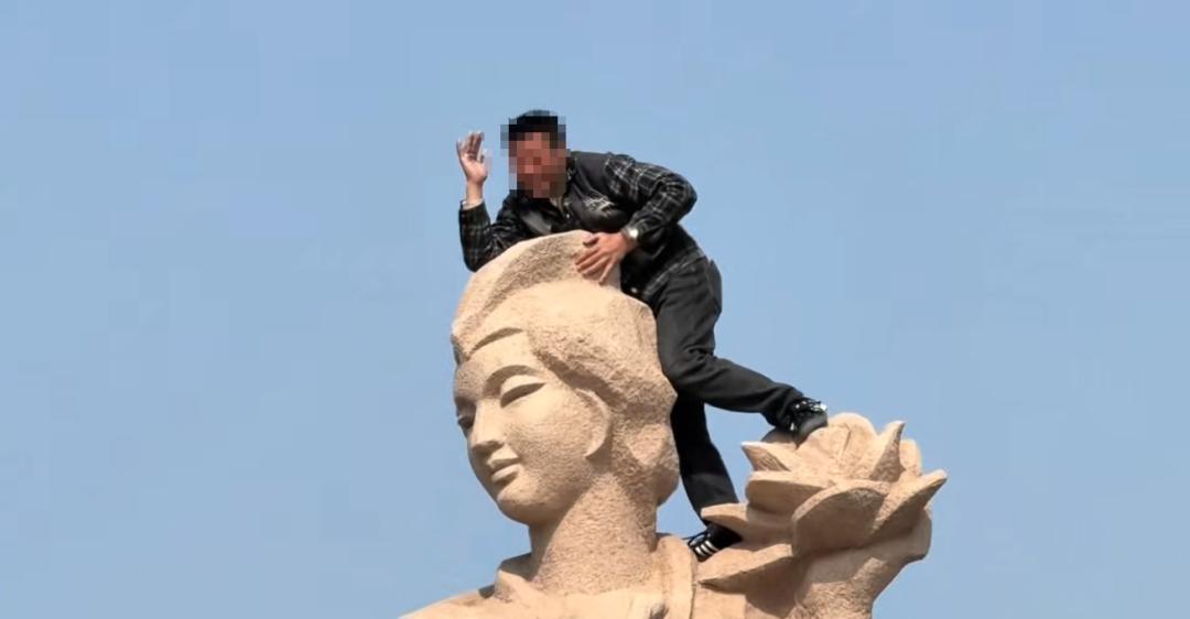 无知无畏，不作不死。烟台蓬莱，一男子爬到八仙雕塑上，脚踩何仙姑的肩膀摆出观音的手