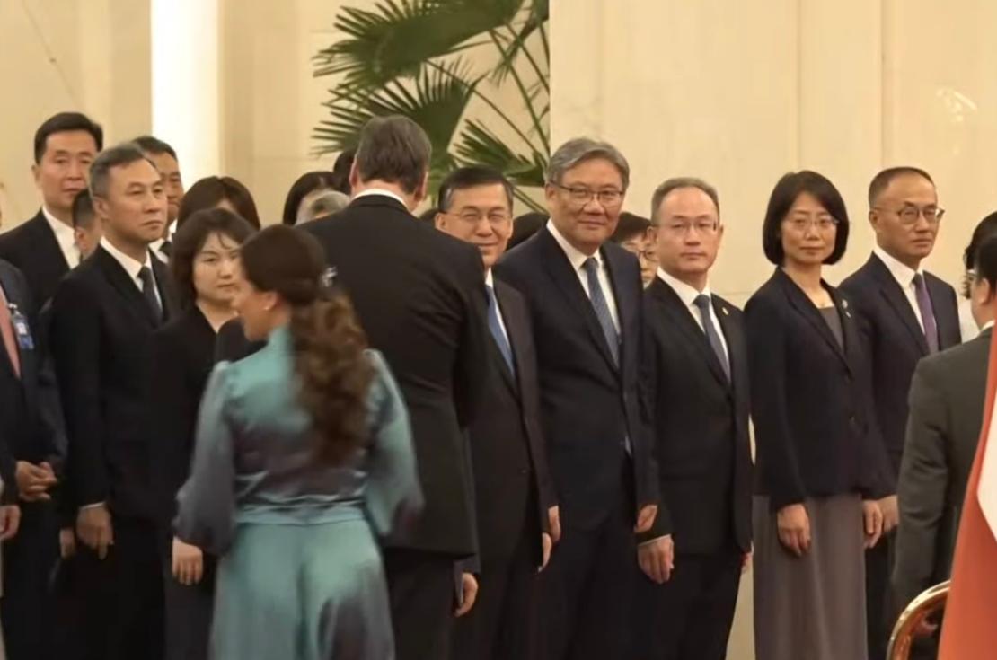 5月25日武契奇在北京欢迎仪式上与中方代表握手一米九八个头瞩目；他虽说不是运动员