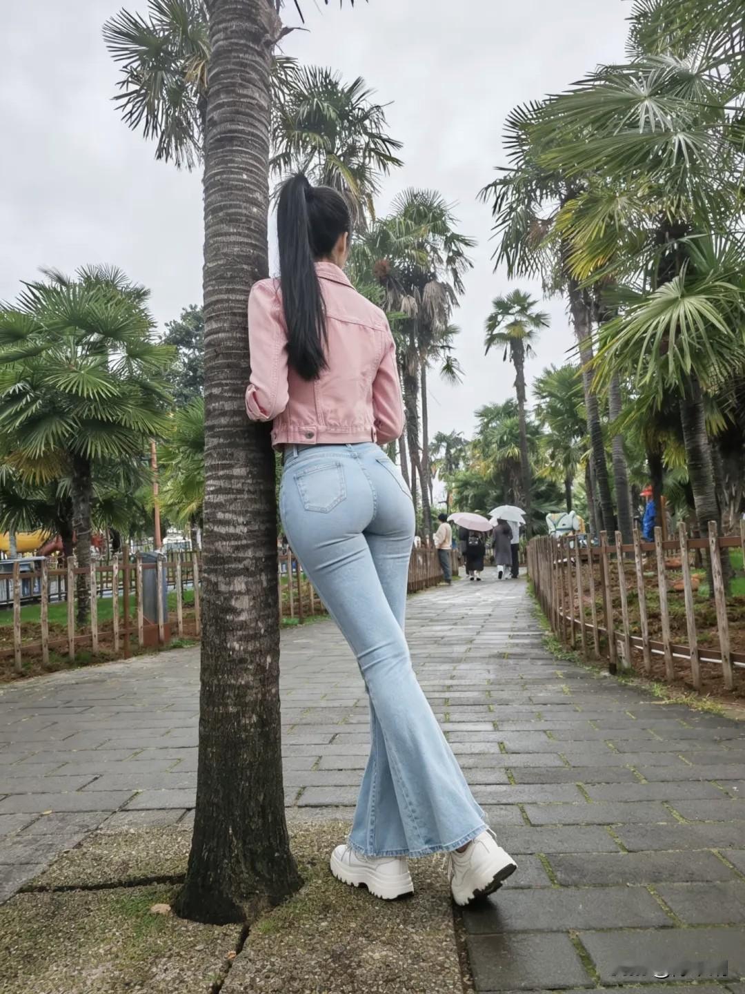 粉衫轻倚棕榈树，
蓝袂斜依石径途。
风摆纤腰凝倩影，
悠然一笑入画图。