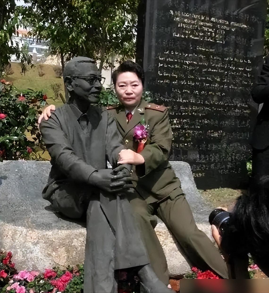 1997年，陈景润的夫人坐在丈夫的雕塑旁边，搂住“丈夫”的肩膀，留下了这张令人垂