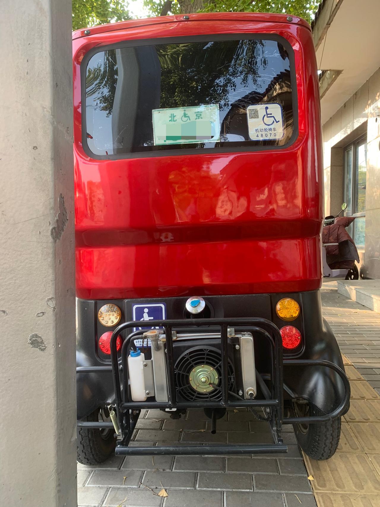 残疾车后面装了个小马达。这是干什么的？是发动机还是空调？或者是暖气片？