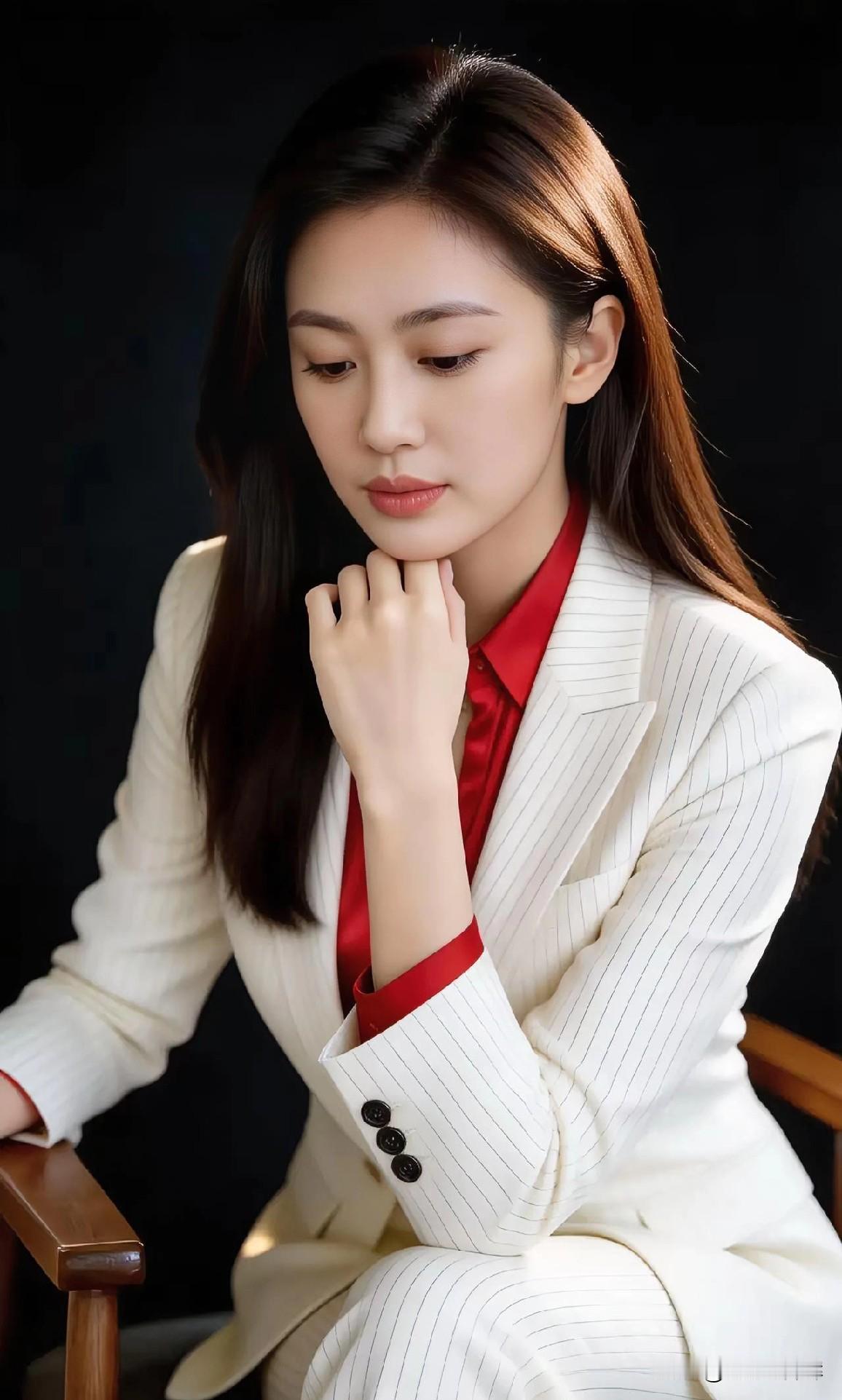 白西装衬红衬衫，指尖轻托腮，气质温婉如诗。