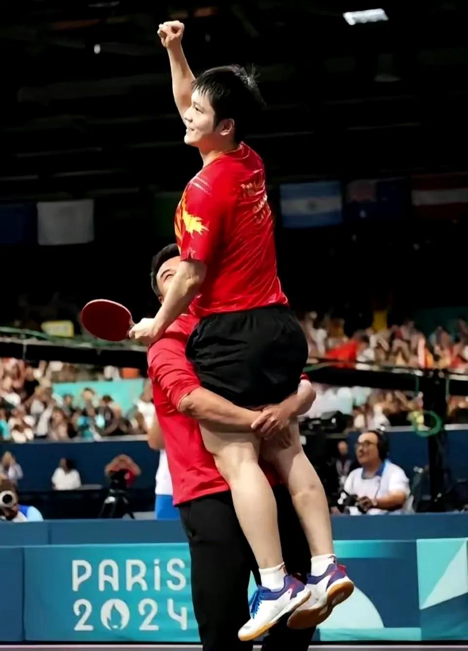 王皓用力的高高抱起樊振东。这张照片真是体现了他们俩的师徒情深啊！从担任樊振东的教