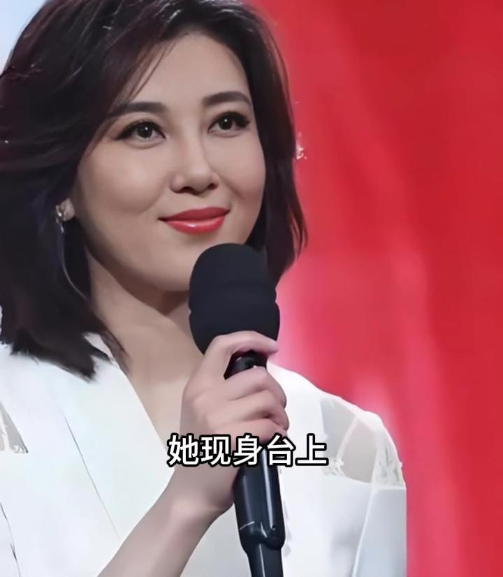 李红神情明媚，浅笑嫣然富有感染力。她现身台上宛如星辰游移生发辉光，她的笑容足以扫