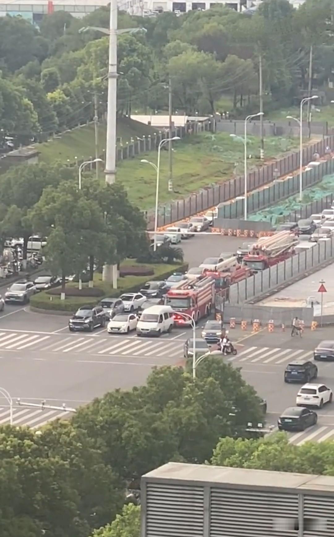 红绿灯口，一辆商务面包车正在等红灯。在它身后，有三辆执行出警任务的消防救援车，尽