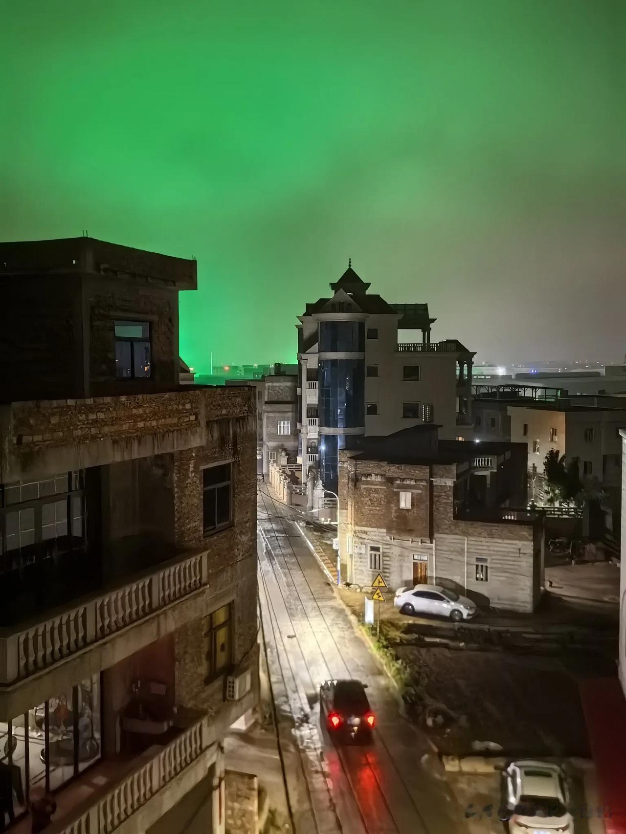 乡村夜色。一场小雨，湿润了乡村道路，把映射到夜空中的灯光渲染得愈加浓稠梦幻。故乡