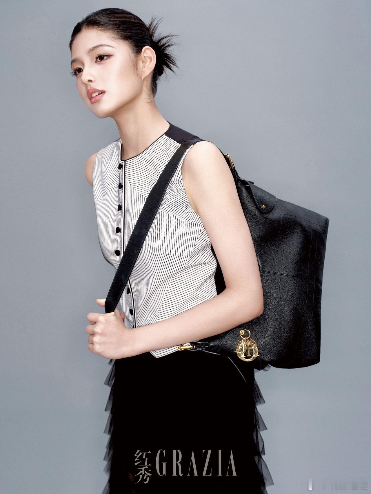 高颅顶丸子头利落率性，裸肩线条与锁骨链光影缠绵，蹙眉抬眼间少女心事藏于指缝，极简