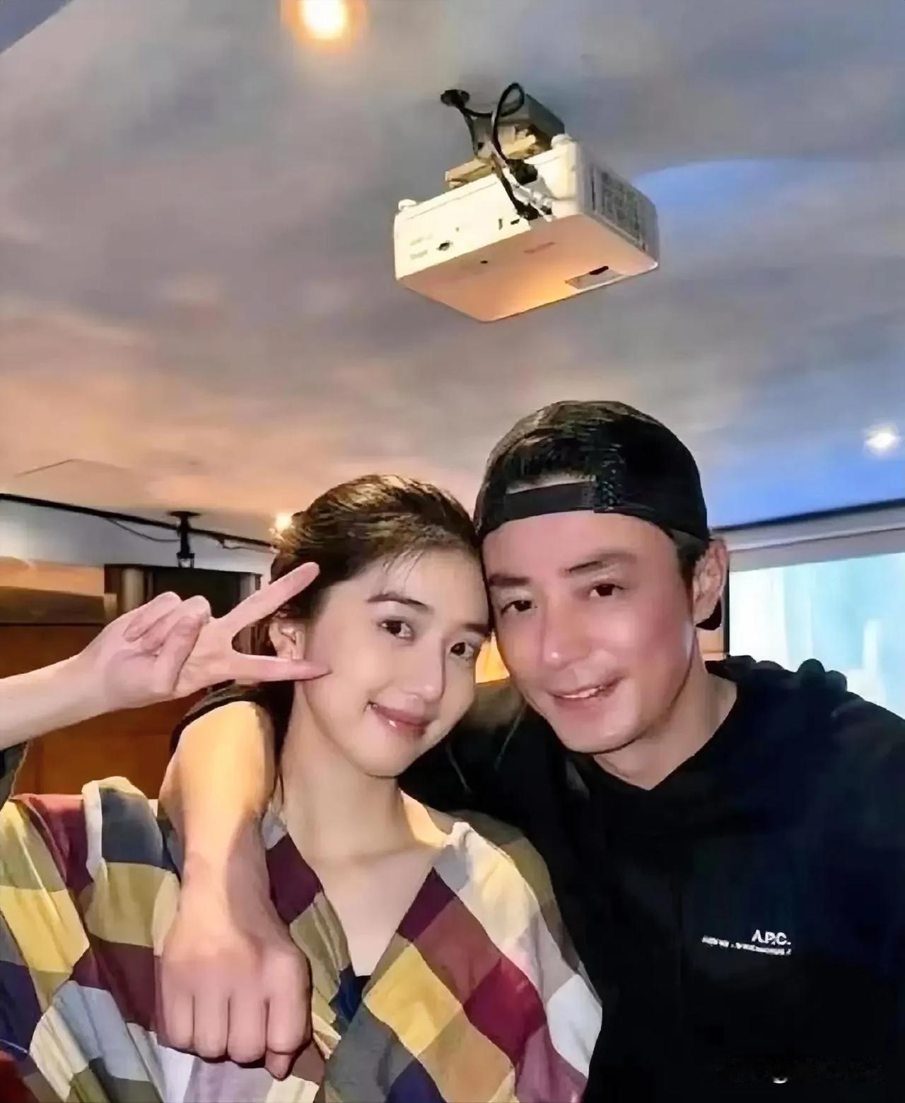 在璀璨的光影下，霍建华绅士地手搂着身旁的美女。女子面容姣好，双眸明亮似星，浅笑盈