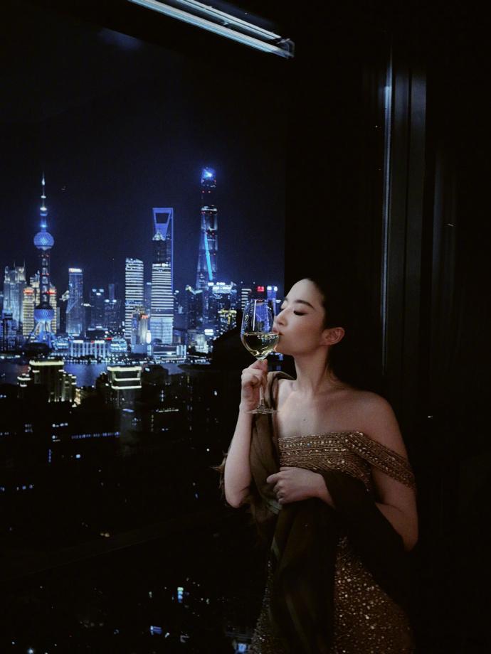 刘亦菲纸醉金迷的代名词繁华盛景衬美人，刘亦菲与魔都灯火夜景同框。鎏金礼服泛着金色