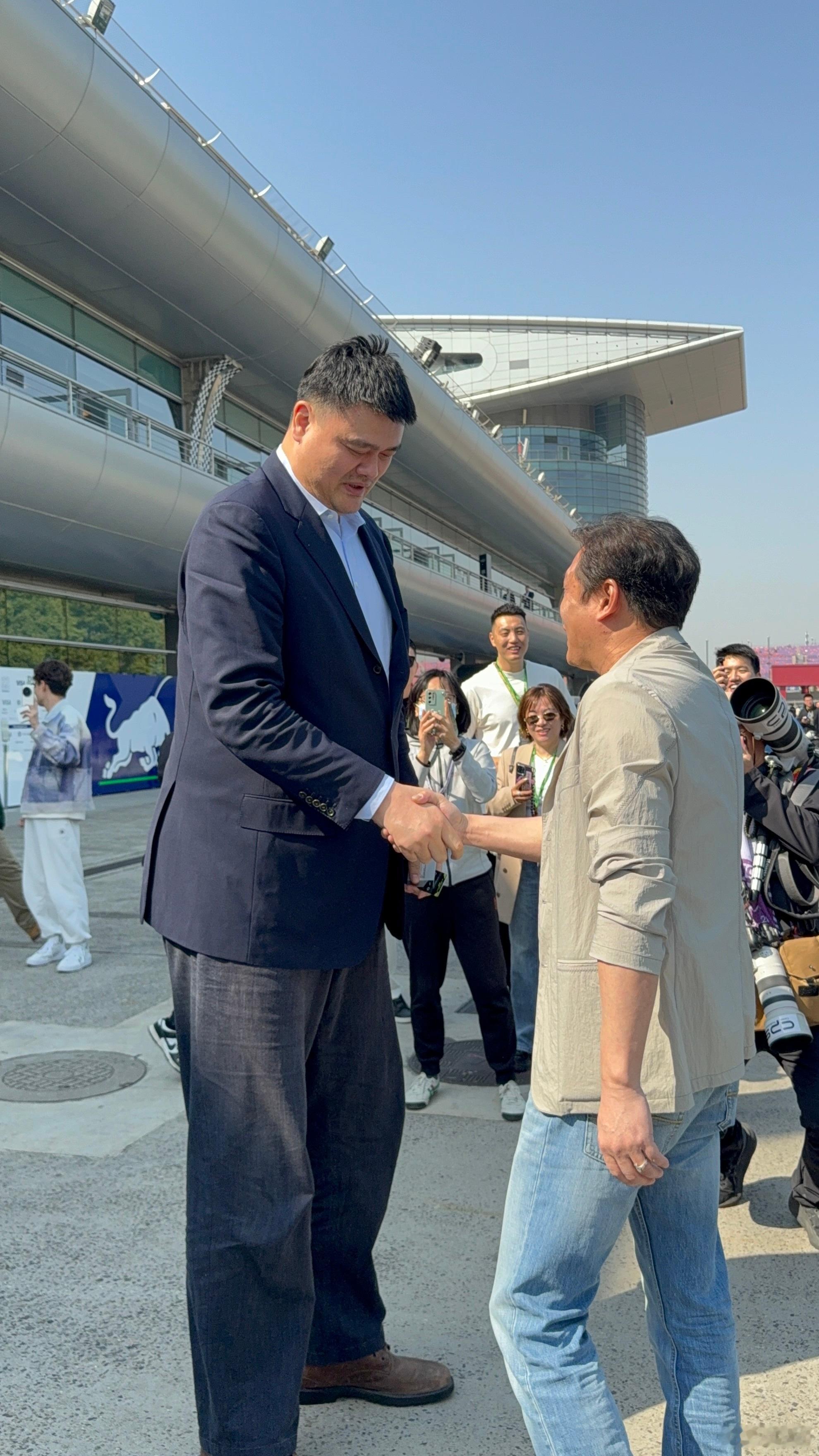 姚明范志毅F1围场同框姚明与范志毅一同出现在F1围场，他们专注热聊，周围的引擎轰