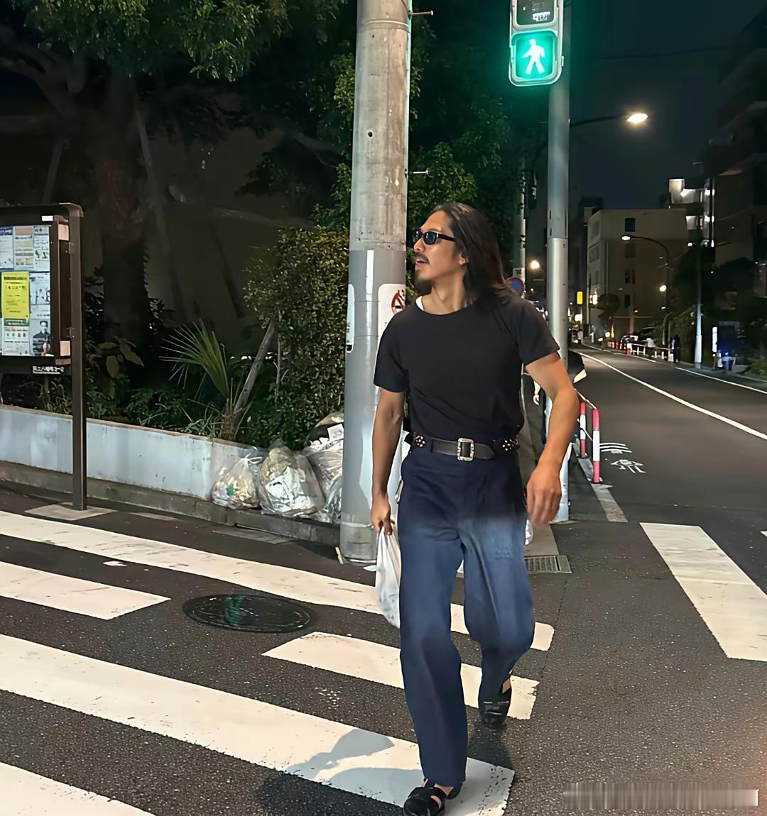 林志玲老公黑泽良平在晚上的街头出现，打扮真的一言难尽，留着一头长发，胡须没刮，不