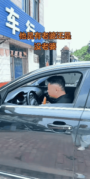 一辆奥迪车停在路边，一个帅哥坐在驾驶位，正津津有味地吃着烧饼，路过的女子决定主动