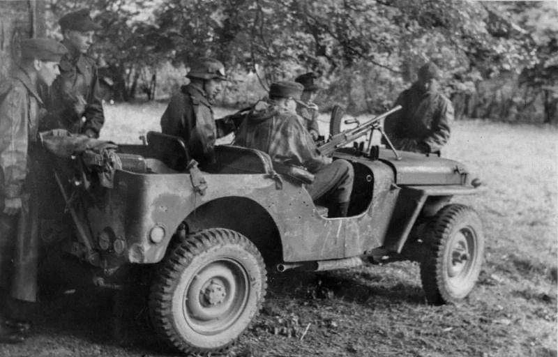 1944年6月，凯恩附近，德军士兵和被缴获威利斯MB吉普车。副驾驶座的士兵手持一