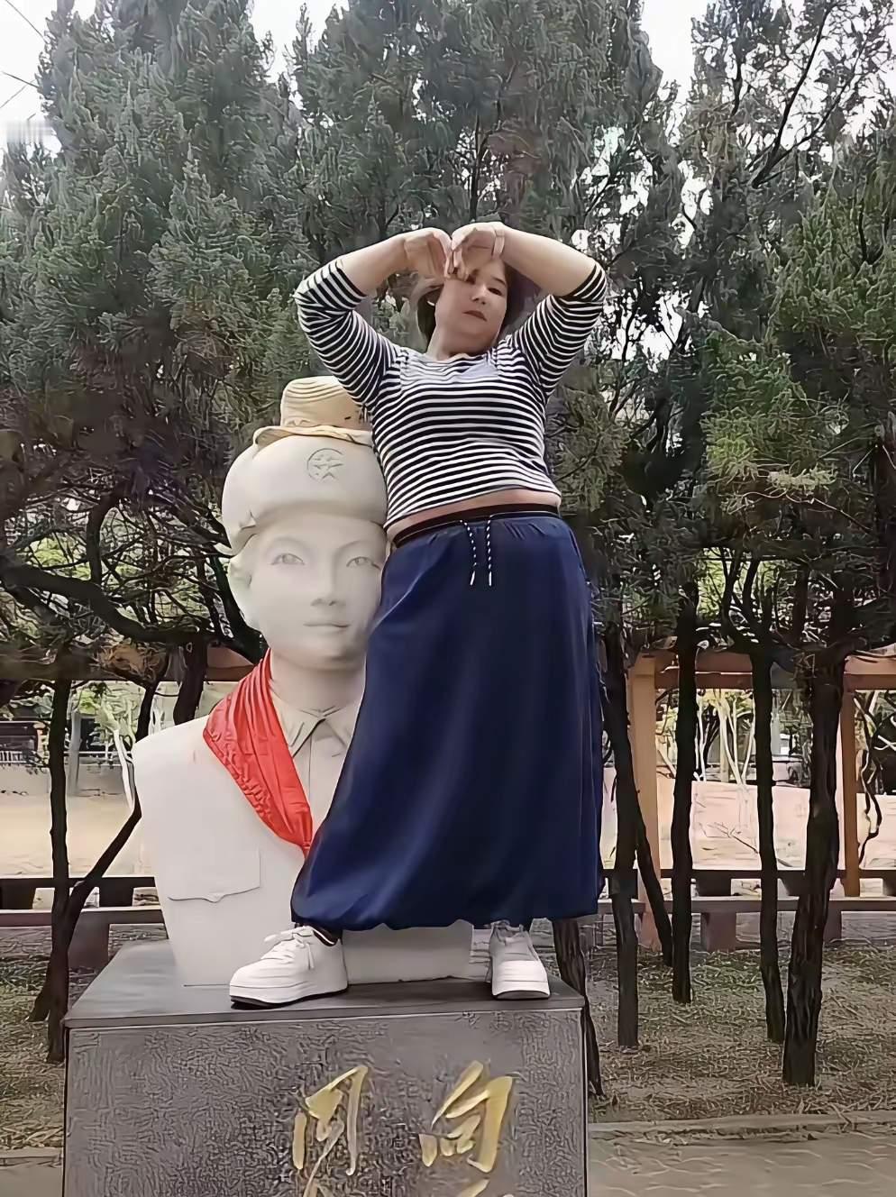 网友们都炸锅了，竟然有人踩踏我们的民族英雄。
她站在我们的民族英雄雷锋同志的雕像
